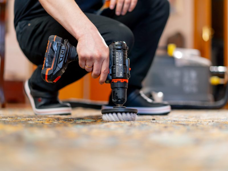 close up in the apartment master cleaner cleans the carpet with detergent using a screwdriver and a brush carpet stain removal mobile al